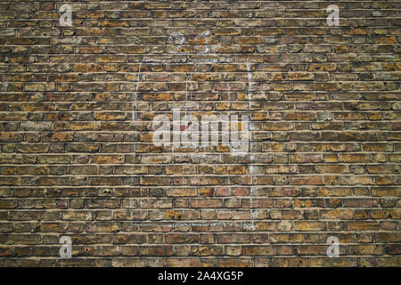 Head-on view of an old yellow and brown brick wall with a doorway drawn on it in chalk. Stock Photo