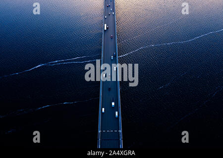Aerial of Tasman bridge over wide flowing Derwent river in Tasmania Australia, with traffic, cars and trucks, crossing at sunset. Stock Photo
