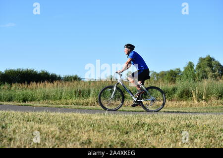 Exercising Athlete Retiree Male Cyclist Wearing Helmet Riding Bike Stock Photo