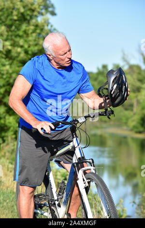 Confused Retiree Athletic Man Wearing Helmet Riding Bike Stock Photo