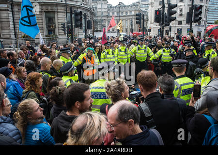 London, UK. 16 October, 2019. Police officers arrest climate activists from Extinction Rebellion who had defied the Metropolitan Police prohibition on Extinction Rebellion Autumn Uprising protests throughout London under Section 14 of the Public Order Act 1986 by sitting in the road in Whitehall. Credit: Mark Kerrison/Alamy Live News