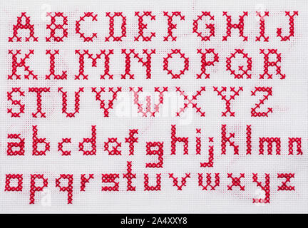 Red Alphabet Cross Stitch Sampler with Upper Case and Lower Case Letters. Stock Photo