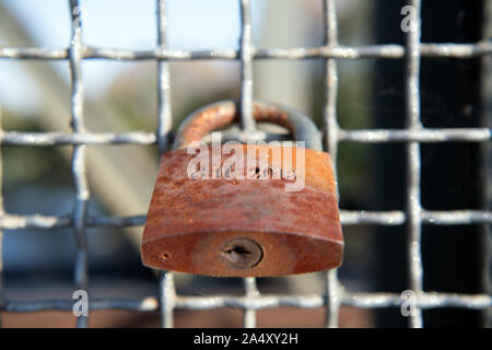 14 October 2019, Brandenburg, Schwielowsee/Ot Geltow: A rusty castle hangs on the grate next to the footpath of the bridge of the bypass from Jüterbog via Beelitz and Potsdam to Oranienburg leading over the Caputher Gemünde. The attachment of love locks to bridge railings symbolizes the eternal love of the lovers with engraved first names or initials. After attaching the lock, the key is usually thrown into the flowing water. Photo: Soeren Stache/dpa-Zentralbild/ZB Stock Photo