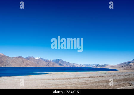 Landscape image of Pangong lake with mountains view and blue sky background Stock Photo