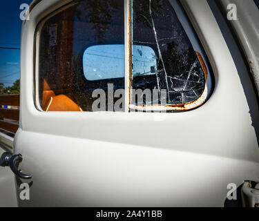 The broken window on an old 1949 pickup truck sitting on a street in southern California. Stock Photo