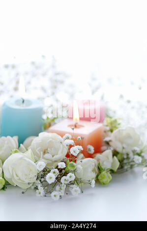 White flower arrangement and candle Stock Photo