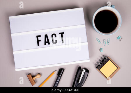 Fact, social media, news, fake and business concept. White lightbox on a gray office desk Stock Photo
