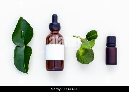 Alternative health care fresh  kaffir llime leaves and oils on marble background. Stock Photo