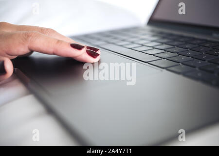 Closeup image of woman's hands using and touching on laptop keyboard with write background Stock Photo