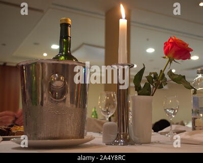 Closeup of wine bottle in bucket of ice on the table in restaurant Stock Photo