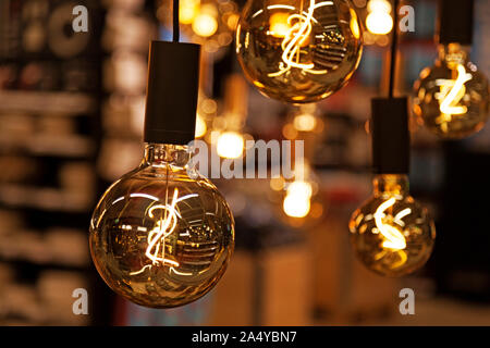 many lighted bulbs hang from the ceiling inside the store Stock Photo
