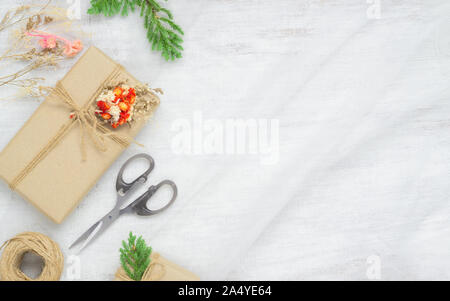 Hand crafted DIY Christmas gift box on nest fabric and white wooden background. Natural present boxes for Christmas, New year or other anniversary. Gr Stock Photo