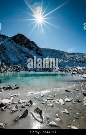 Türkisfarbener See auf der Macun Seenplatte im ersten Schnee im Herbst Stock Photo