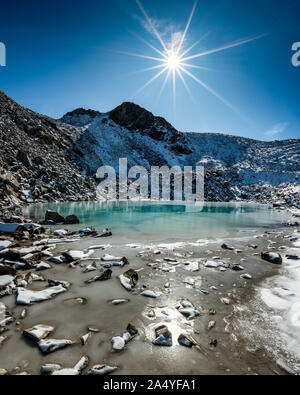 Türkisfarbener See auf der Macun Seenplatte im ersten Schnee im Herbst Stock Photo