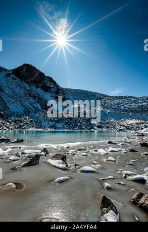 Türkisfarbener See auf der Macun Seenplatte im ersten Schnee im Herbst Stock Photo