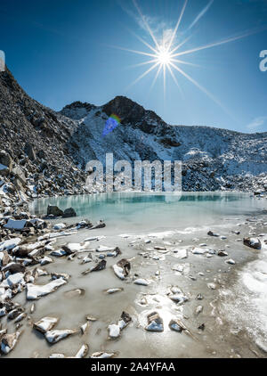 Türkisfarbener See auf der Macun Seenplatte im ersten Schnee im Herbst Stock Photo