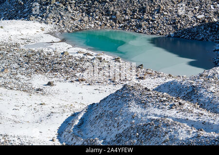 Türkisfarbener See auf der Macun Seenplatte im ersten Schnee im Herbst Stock Photo