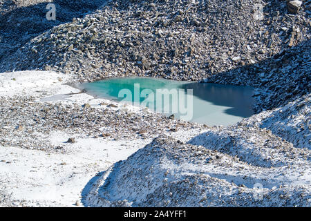 Türkisfarbener See auf der Macun Seenplatte im ersten Schnee im Herbst Stock Photo