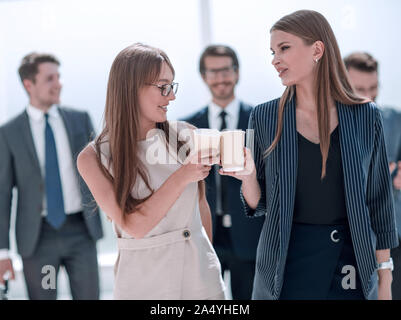 employees with cups of coffee discussing something during a work break Stock Photo