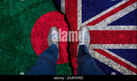 Business man stands on cracked flag of UK and Bangladesh. Political concept Stock Photo
