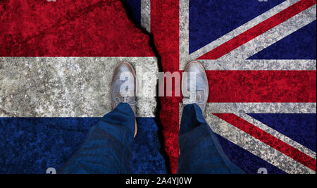 Business man stands on cracked flag of UK and Netherlands. Political concept Stock Photo