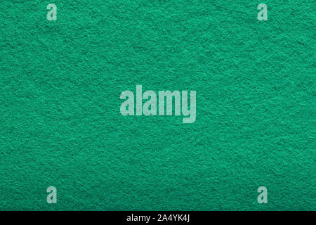 a shaggy surface. Fine grain felt green fabric. artificial grass. fleecy texture background. Stock Photo