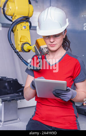 A young female technician while machine constructing in a manufacturing plant Stock Photo