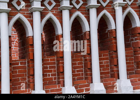 A row of white columns is an architectural element of the old castle of red brick built in the Gothic style Stock Photo