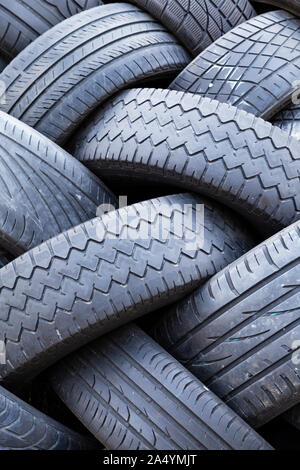 Close-up of a stack of old car tires with worn down profiles piled up in an interwoven pattern Stock Photo