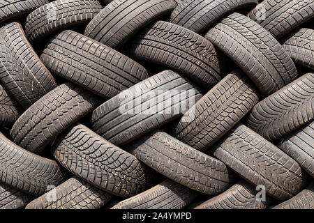 Close-up of a stack of old car tires with worn down profiles piled up in an interwoven pattern Stock Photo