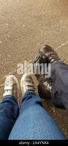 Man and a woman’s stretched out legs with shoes Stock Photo