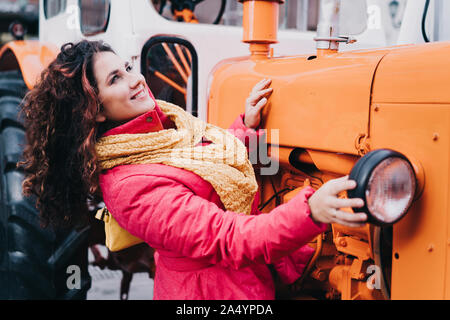 Beautiful cheerful curly red-haired woman in a bright pink trigger Stock Photo
