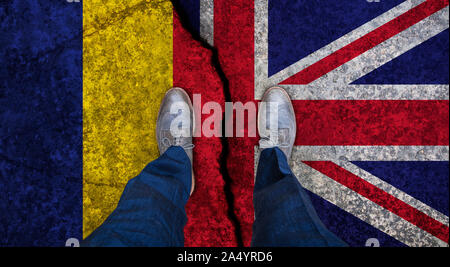 Business man stands on cracked flag of UK and Romania. Political concept Stock Photo