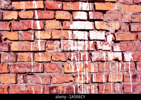 White paint stains, plaster on red brick wall surface close up detail, grunge horizontal shabby background Stock Photo