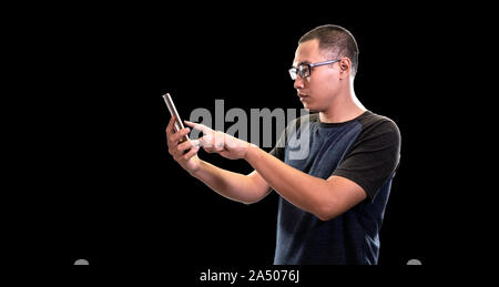 Young asian men using smartphone for social media isolated on black background. Technology with people concept Stock Photo