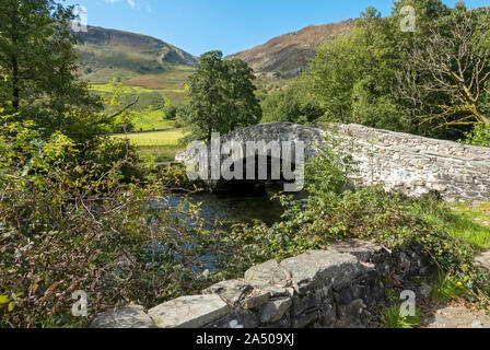 New stone Packhorse Bridge across River Derwent on the Cumbria Way Rosthwaite Borrowdale Lake District National Park in Autumn Cumbria England UK Stock Photo