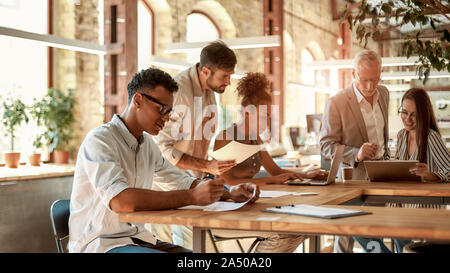 Collaboration. Group of concentrated business people working together and communicating in the modern office Stock Photo