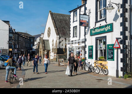 People walking by The Wainwright pub bar inn Lake Road Keswick Lake District National Park Cumbria England UK United Kingdom GB Great Britain Stock Photo