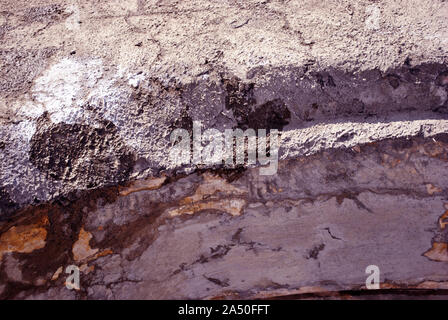 Cracked gray paint, plaster surface on wall, grunge horizontal shabby background detail close up Stock Photo