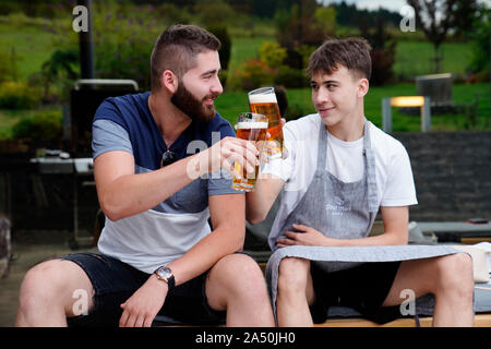 two friends tapping glasses of beer, Karlovy Vary, Czech Republic Stock Photo