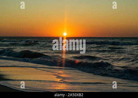 Sunrise over the Black sea, waves on the sandy beach Stock Photo
