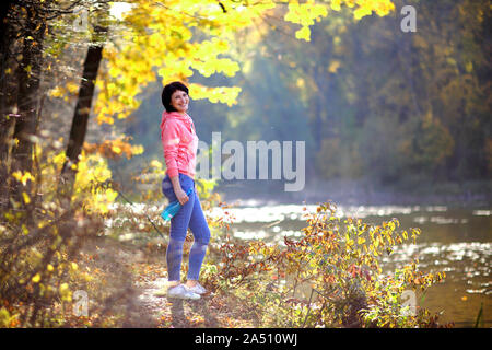 Girl in a yellow autumn forest. Beautiful young woman walks along the path of the autumn forest. Stock Photo