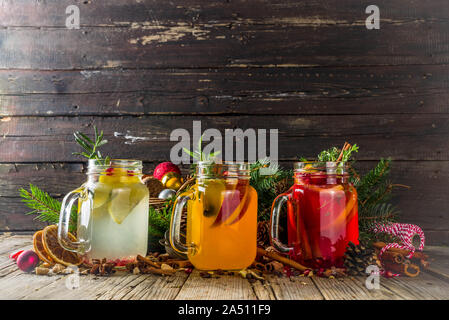 Autumn winter sangria, mulled wine or hot spiced cider cocktails. Red, white and orange hot winter drinks and beverages, in glass mason jar mugs with Stock Photo