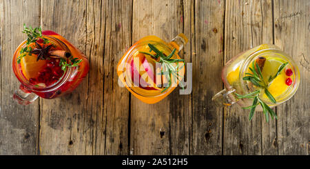 Autumn winter sangria, mulled wine or hot spiced cider cocktails. Red, white and orange hot winter drinks and beverages, in glass mason jar mugs with Stock Photo