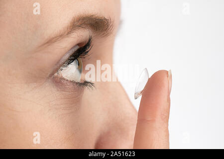 Close-up of a womans head who wants to insert a contact lens Stock Photo
