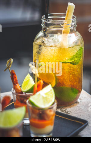 Classic cuban mojito with lime, mint and black sugar served in a big glass and prawn skewer tapas Stock Photo