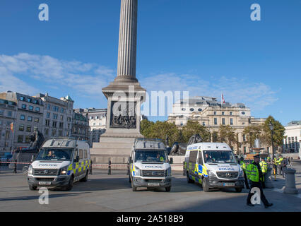Trafalgar Square, London, UK. 17th October 2019. Large early morning police presence in Trafalgar Square after Extinction Rebellion climate change protesters were stopped from gathering in the area. Vans parked from Essex Police, Kent Police and Norfolk Constabulary. Credit: Malcolm Park/Alamy Live News.