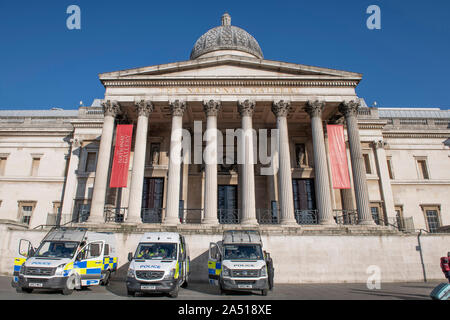 Trafalgar Square, London, UK. 17th October 2019. Large early morning police presence in Trafalgar Square after Extinction Rebellion climate change protesters were stopped from gathering in the area. Vans parked from Essex Police, Kent Police and Norfolk Constabulary. Credit: Malcolm Park/Alamy Live News.