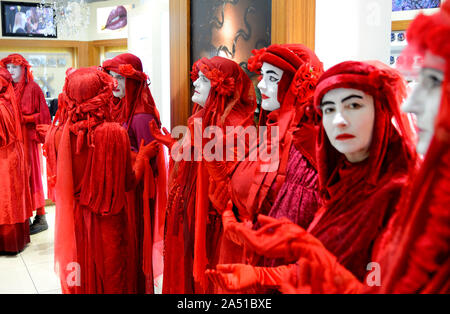 London, UK. 17th October 2019. Despite a city-wide ban on protests, member of Extinction Rebellion's Red Brigade walk slowly from Trafalgar Square to Covent Garden, ending up in a make-up shop, possibly due to the wet weather Credit: PjrFoto/Alamy Live News