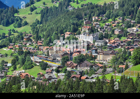 Overview of the village of Wengen in the Swiss Alps, with train visible in the station, Bernese Oberland, Switzerland Stock Photo